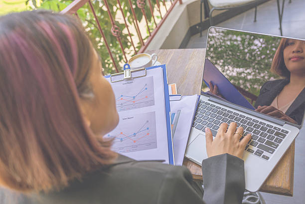 istock Woman working with laptop and document at balcony cafe 533055312