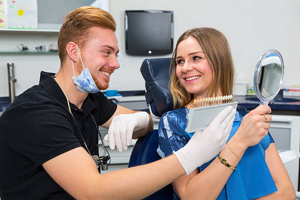 istock Dentist advises patient about color of tooth implants 533055644