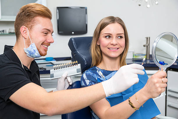 istock Dentist counseling patient about color of teeth implants 533055844