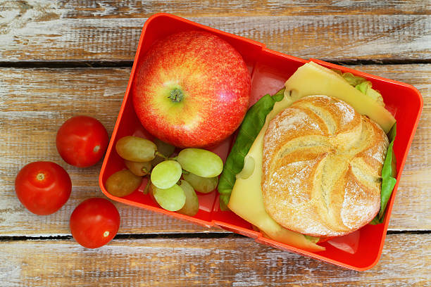 istock Lunch box containing cheese sandwich, red apple, grapes, cherry tomatoes 533059328