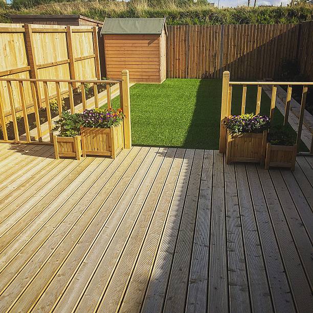 The finished garden Brand new decking and artificial grass played in new build house's back garden. This image was taken on a mobile device outdoor shed stock pictures, royalty-free photos & images