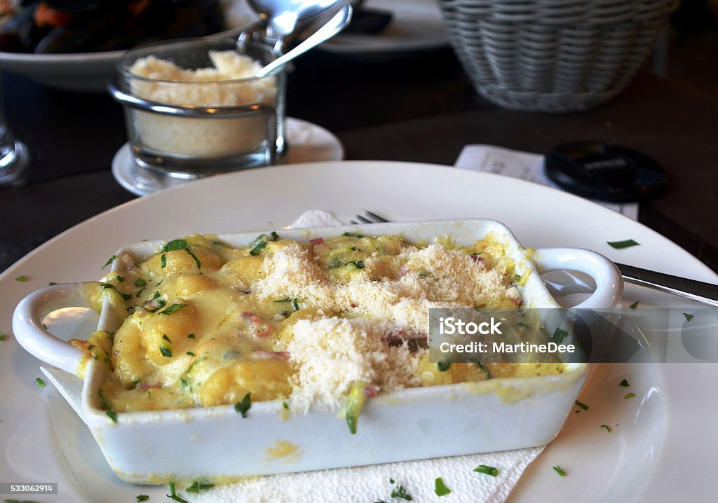 Gnocchi with parmesan cheese baked Gnocchetti with cheese baked on a white bowl on a table Backgrounds Stock Photo