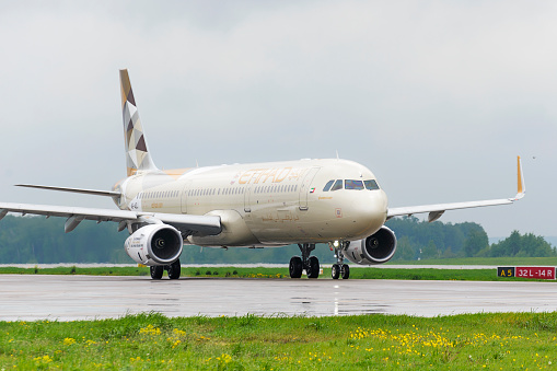 Moscow, Russia - May 19, 2016:  Etihad airlines Airbus A321 taxiing. Plane makes taxiing on taxiway Domodedovo International Airport. Rainy and cloudy day.