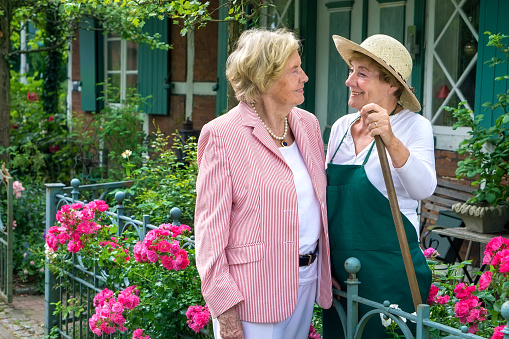 Two Senior Women Talking Together in Garden.