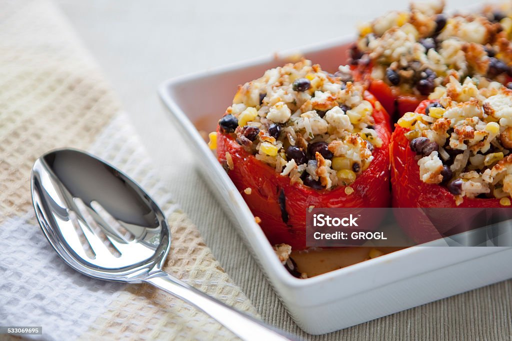 Roasted peppers stuffed with corn, rice and black beans A dish full of roasted peppers stuffed with corn, rice and black beans, sits on a table ready to be served. Stuffed Pepper Stock Photo