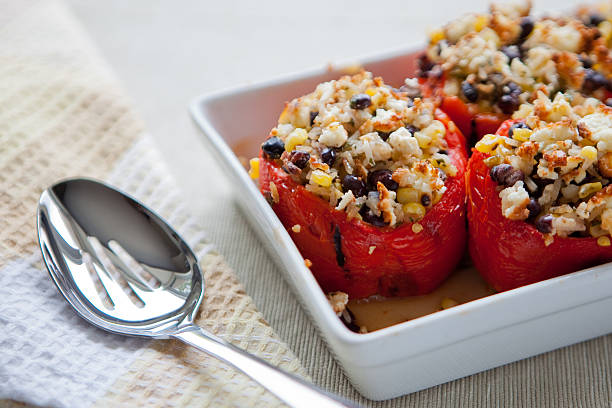 Roasted peppers stuffed with corn, rice and black beans A dish full of roasted peppers stuffed with corn, rice and black beans, sits on a table ready to be served. stuffed pepper stock pictures, royalty-free photos & images