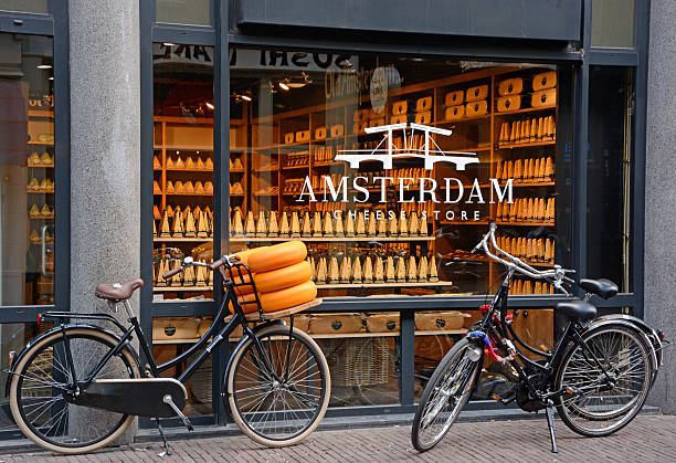 Amsterdam Amsterdam, The Netherlands - May 4th, 2016: Shop window of a cheese store in Amsterdam. Three bicycles parked in front of the store. Assortment of cheese visible through the window. Horisontal, outdoor image cheese market stock pictures, royalty-free photos & images