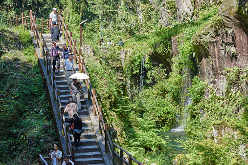 Takachiho, Japan - September 28, 2014: a group of japanese tourists while walking down the stairs while visiting the Takachiho Gorge.