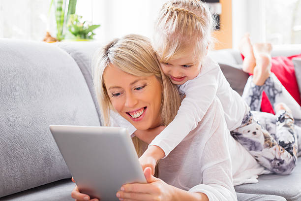 istock Little girl with her mother using tablet computer 533072799