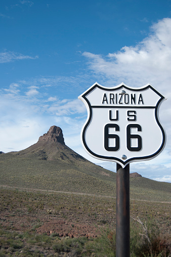 Route 66 sign with steep bluff in background typical of Arizona landscape.