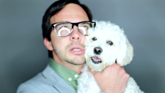 Geek embracing adorable white doggie