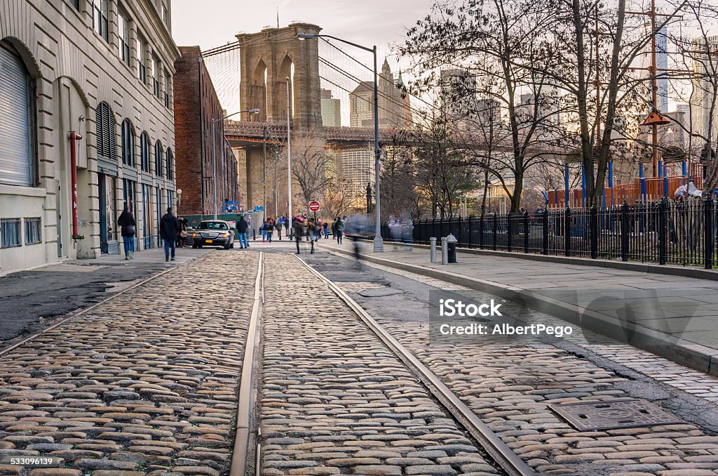 Cobbled Street in Brooklyn Tram track on a cobbled street in Brooklyn at sunset. the Brooklyn Bridge is in the background. Brooklyn - New York Stock Photo