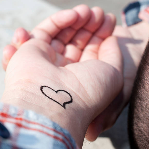 istock young man with a heart ttatooed in his wrist 533103157