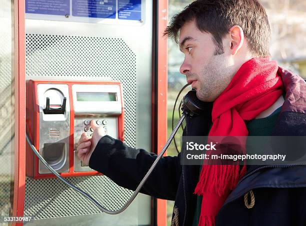 Young Man Dialing Phone Number At Public Phone Box Stock Photo - Download Image Now - 20-29 Years, 2015, Adult