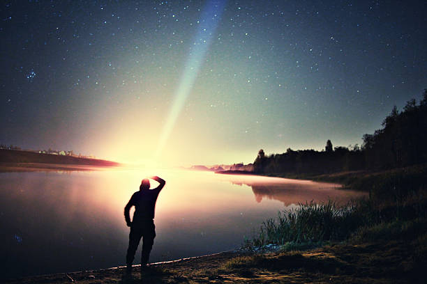 istock night man at Lake starry sky space alien 533135395