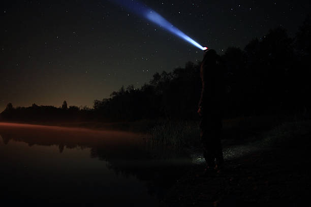 istock night man at Lake starry sky space alien 533135419