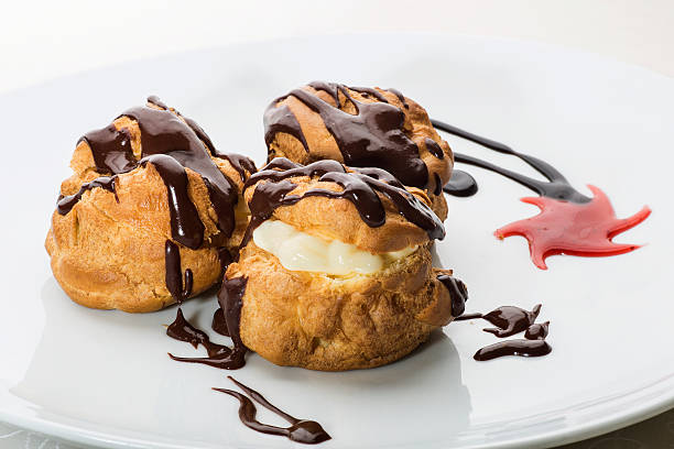 Handcrafted éclairs topped with milk chocolate sauce stock photo
