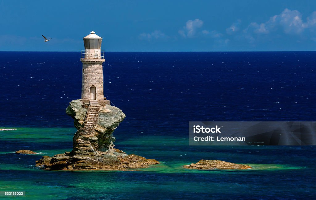 Lighthouse Tourlitis in Andros island, Cyclades, Greece The beautiful Lighthouse Tourlitis of Chora in Andros island and a seagull, Cyclades, Greece Lighthouse Stock Photo