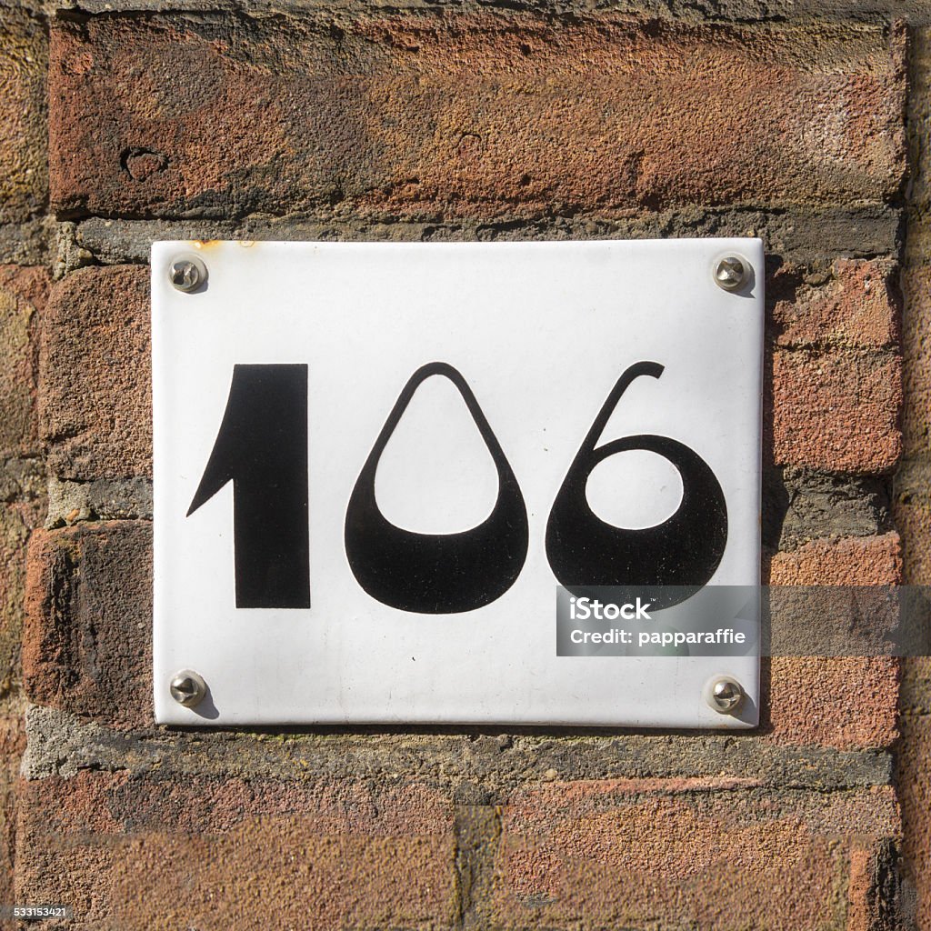 house number 106 enameled house number one hundred and six. Black lettering on a white background. 2015 Stock Photo