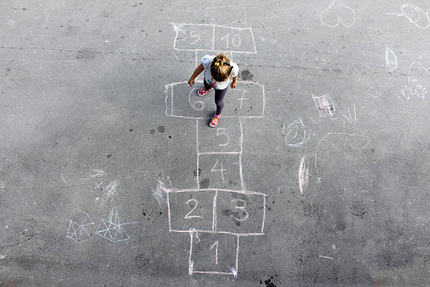 Girl on the hopscotch Girl on the hopscotch schoolyard stock pictures, royalty-free photos & images