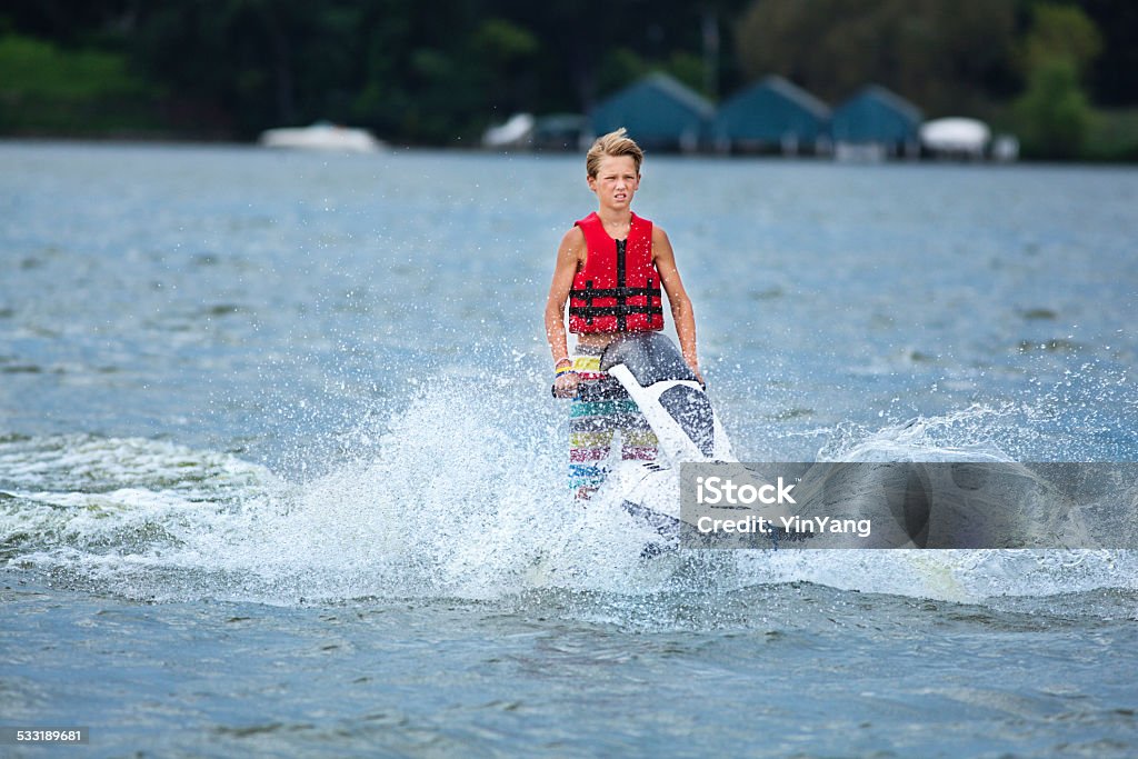 Happy Boy Enjoying Jet Ski in Summer Vacation A teen boy having fun on jet ski boat. Adolescence Stock Photo