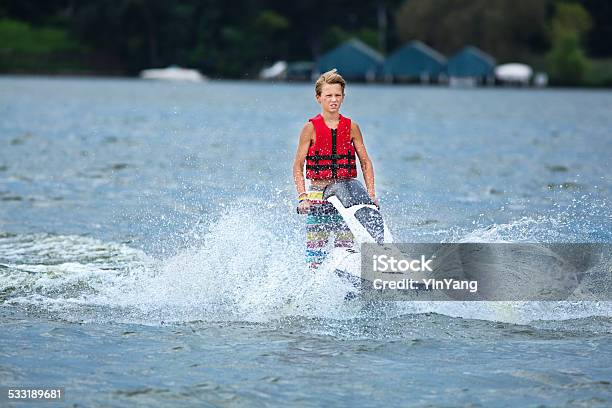 Happy Boy Enjoying Jet Ski In Summer Vacation Stock Photo - Download Image Now - Adolescence, Life Jacket, Teenager
