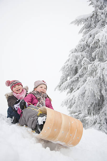 Kid sliding with sledding in the snow. 