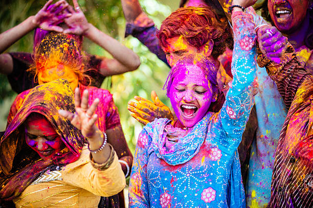 indian amici ballare coperti da holi colorati in india polvere - holi foto e immagini stock