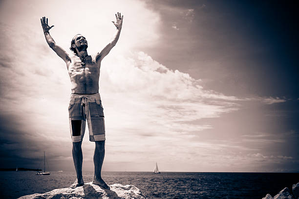 young man by the mediterranean sea, on the rocks along the shoreline in piran.