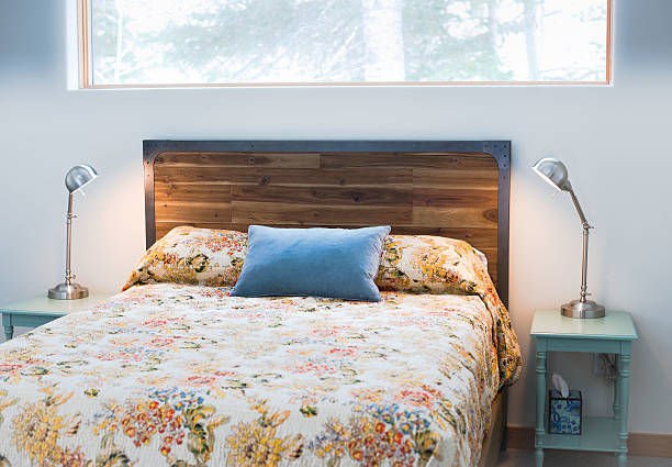 クイーンベッド 1 台、花のベドカバー、木製ヘッドボード - cabin indoors rustic bedroom ストックフォトと画像