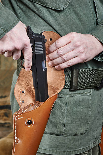 istock Soldier puts gun in holster 533196955