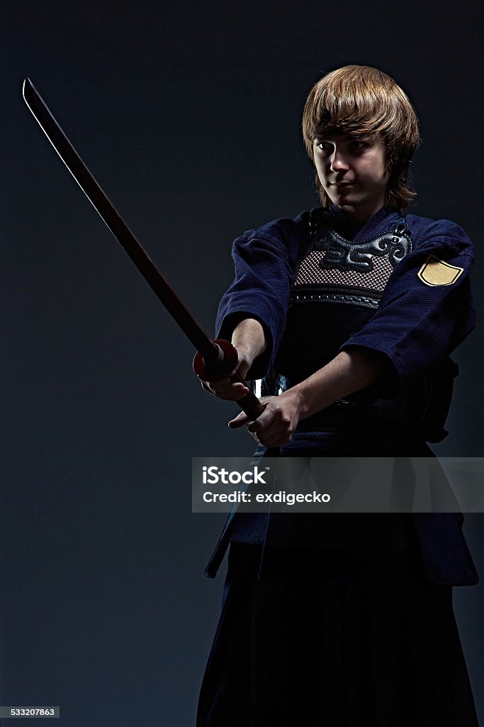 portrait of a kendo fighter with bokken portrait of a kendo fighter with bokken, dark background Activity Stock Photo