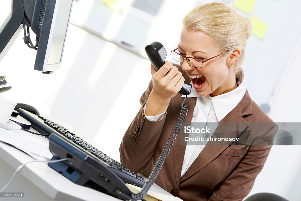 Rough chief A young businesswoman shouting in telephone receiver 2015 Stock Photo
