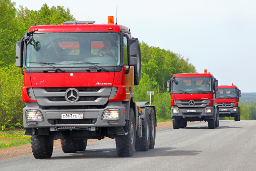 Tatarstan, Russia - May 20, 2013: Brand new red Mercedes-Benz Actros semi-trailer trucks drives at the interurban road.