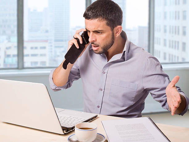 istock businessman at office talking upset on phone working with computer 533210413