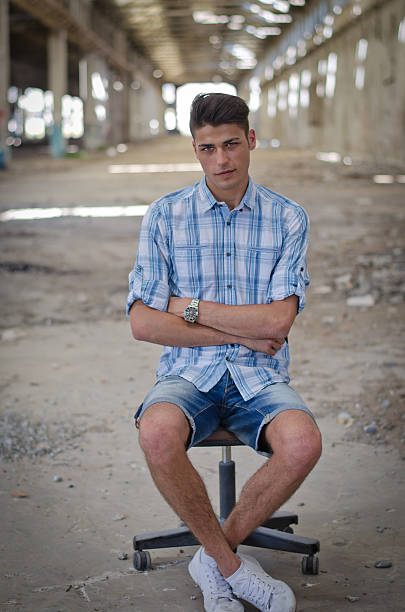 istock Young man sitting on office chair in abandoned warehouse 533211275