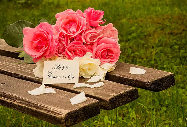 pink roses on a wooden bench for women's day
