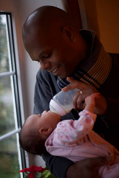 istock african descent father smiling breastfeeds her child 533213647
