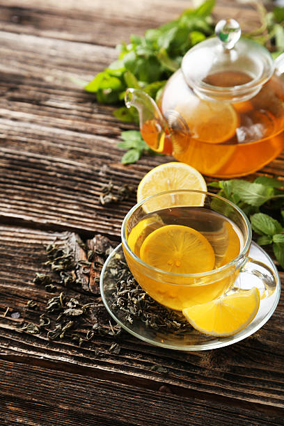 istock Cup with green tea and teapot on brown wooden background 533214531