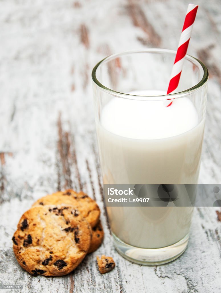 Chocolate chip cookie and glass of milk Chocolate chip cookie and glass of milk on a wooden background 2015 Stock Photo