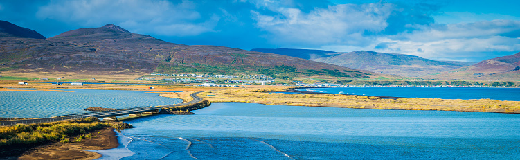 Panoramic view across the causeway to Saudarkrokur, the largest town in northwest Iceland, nestled between mountains and Arctic Ocean fjord. ProPhoto RGB profile for maximum color fidelity and gamut.