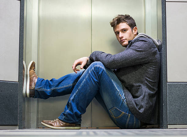 istock Handsome young man sitting in front of elevator doors 533225249