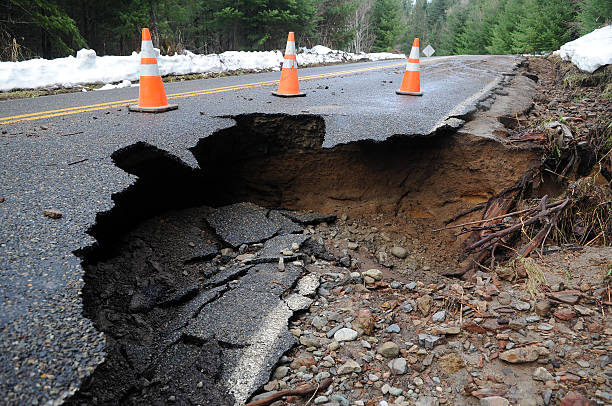 Damaged roadway A sinkhole claims a piece of paved road in the Cascade Mountains. sinkhole stock pictures, royalty-free photos & images
