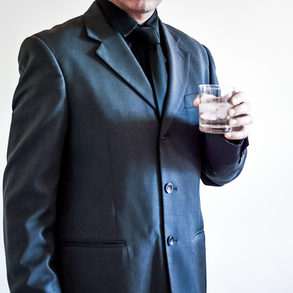 unrecognizable businessman in suit holding a drink