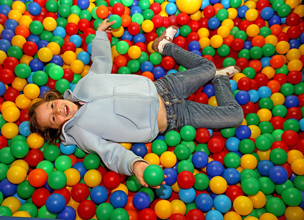 istock nice little girl play dipped in colored balls 533227221