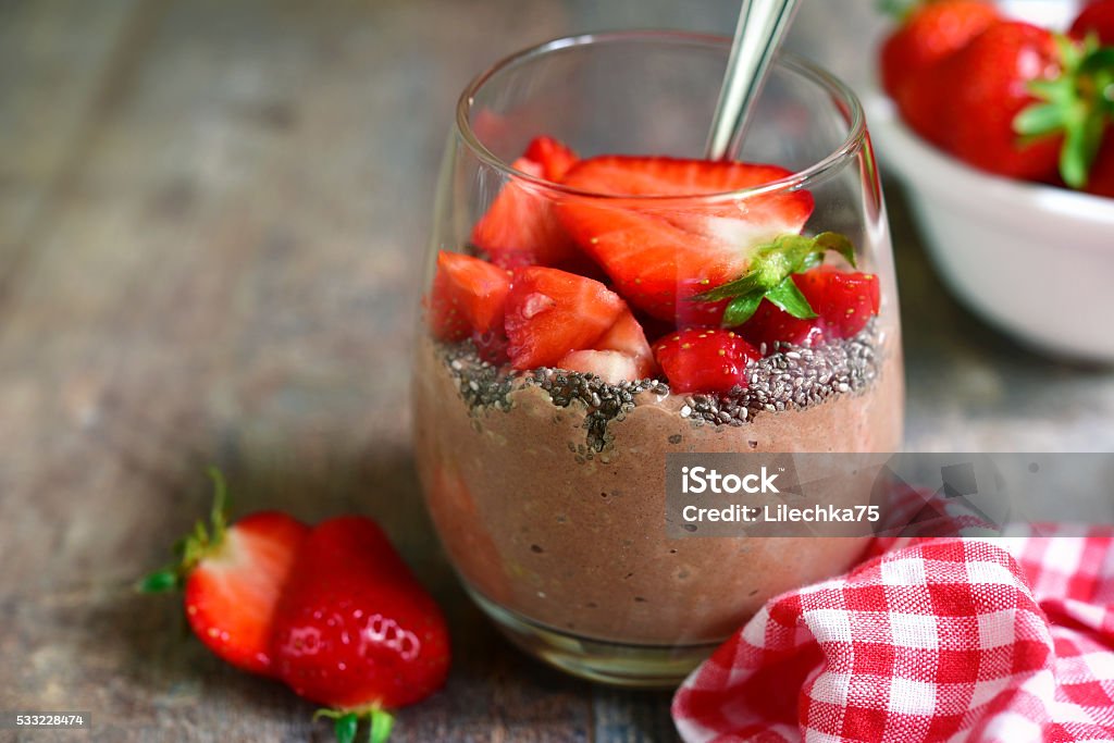 Chocolate chia seed pudding with strawberry. Chocolate chia seed pudding with strawberry in a glass on a rustic wooden table. Chia seed Stock Photo