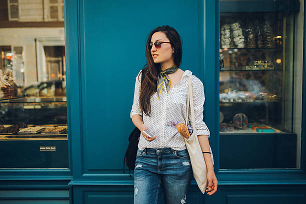 giovane donna parigina acquisto in un panificio - street style foto e immagini stock