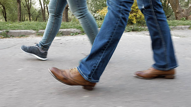 damen füße auf dem gehweg in schuhen und sneakers - sidewalk walking human foot city stock-fotos und bilder