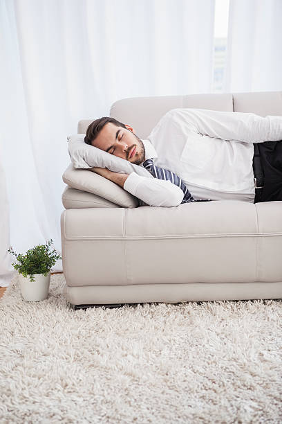 istock Businessman sleeping on couch after long day 533229733