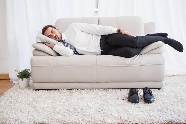 istock Businessman sleeping on couch after long day 533229737